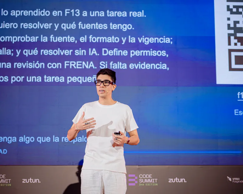 Sebastian Bimbi explaining a point with one hand raised at F13 Code Summit.