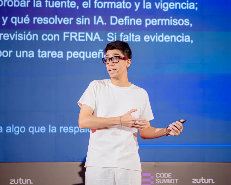 Sebastian Bimbi gesturing with a presentation remote during his F13 Code Summit talk.
