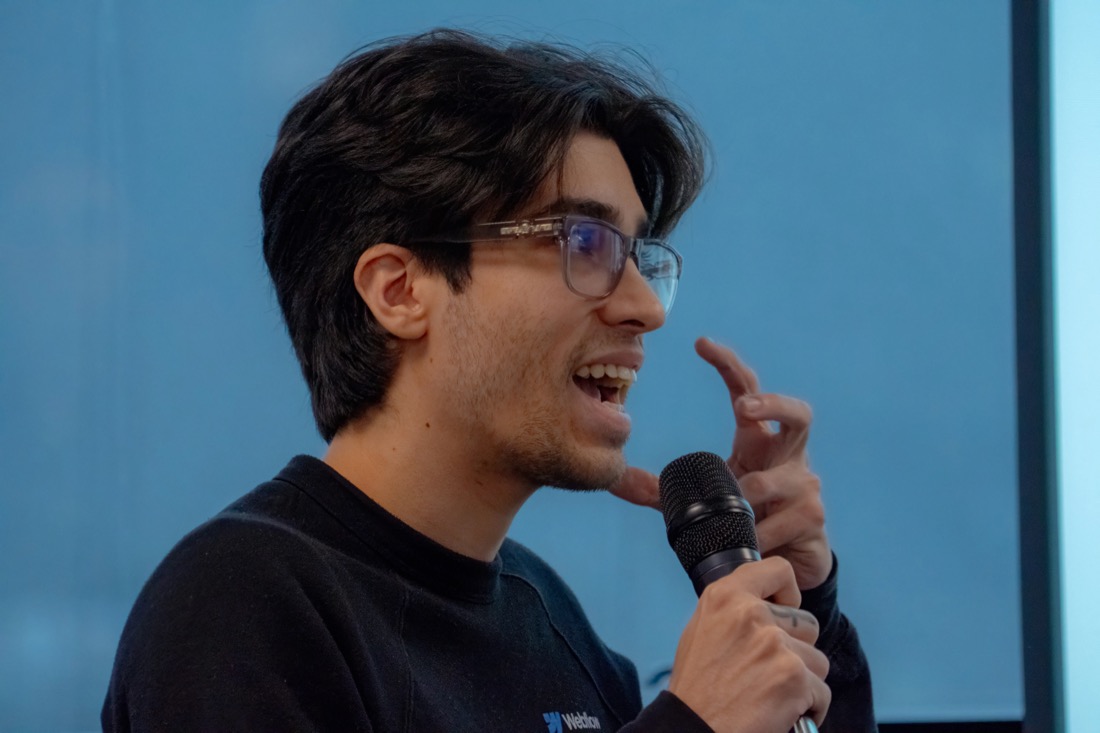 Sebastian Bimbi speaking into a handheld microphone.